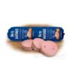 Rolka Brit Premium Dog Chicken and Rabbit saláma pre psov 800g s tromi plátkami na drevenom povrchu.