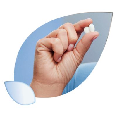 Ruka drží dve biele oválne tabletky Magne B6 FORTE, na modrom pozadí s okrajom v tvare listu.