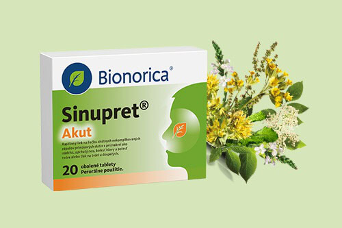 Krabička Bionorica Sinupret Akut tabliet vedľa zväzku žltých a bielych kvitnúcich bylín na svetlozelenom pozadí.