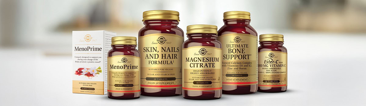 Šesť fliaš a krabičiek doplnkov Solgar: MenoPrime, Skin, Nails and Hair Formula, Magnesium Citrate, Ultimate Bone Support a Ester-C Plus Vitamin C na svetlom podklade.