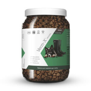 Priehľadný plastový pohár s nápisom Verm-X granule proti črevným parazitom pre psov 650g, na etikete je pes a čierne čižmy.